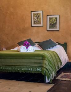 Una cama con dos toallas y flores. en Hacienda San Francisco, en Tumbabiro