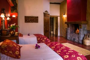 a hotel room with two beds and a fireplace at Hacienda San Francisco in Tumbabiro