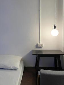 um quarto com uma cama, uma mesa e uma luz em Chatel BKK em Bang Rak