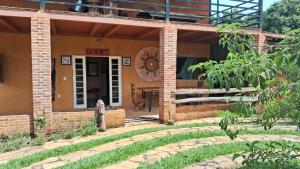 uma casa de tijolos com um pátio e uma mesa em Hostel Vila Mamulengo em Alexânia