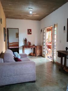 uma sala de estar com um sofá e uma porta aberta em Hostel Vila Mamulengo em Alexânia