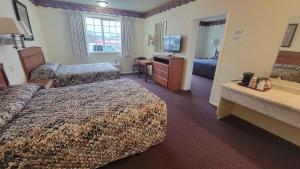 Oceanview Inn and Suites في كريسنت سيتي: غرفه فندقيه سريرين وتلفزيون