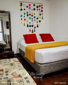 2 camas en una habitación con espejo en The Canarys Hostal, en Santa Rosa de Cabal
