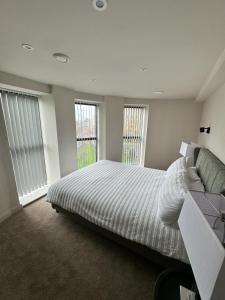 1 dormitorio con 1 cama, 1 sofá y 2 ventanas en 2 Bedroom City Centre Penthouse en Leeds