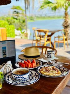 Hotel Boutique Punta Jamaica في أكابولكو: طاولة مع أطباق من الطعام و الكمبيوتر المحمول
