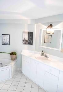 a white bathroom with a sink and a tub at The Jypsy Inn Chambre Damour Bracebridge in Bracebridge +11 photos