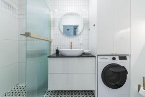 a bathroom with a sink and a washing machine at Golden Azzure by Grand Apartments in Gdańsk