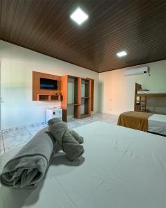 Un dormitorio con una cama con una toalla. en Bonito Suítes en Bonito