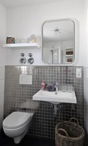 uma casa de banho com um lavatório, um WC e um espelho. em Gästehaus Ferienwohnung Abendstern em Rust