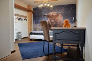 un dormitorio con una pintura de un toro en la pared en Loft industriel dans une ancienne grange 