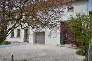 Casa blanca con puerta roja y entrada en Loft industriel dans une ancienne grange, en Guenviller