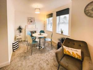 a living room with a couch and a table and chairs at The Sashes - Apartment Two - FREE Parking - Ultrafast WIFI - Smart TV - Netflix - sleeps up to 6! Close to Poole Town Center & Sandbanks & Bournemouth in Poole