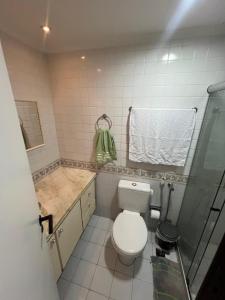 uma pequena casa de banho com WC e chuveiro em Pituba sol flat em Salvador