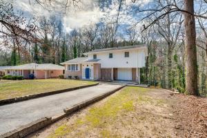 a white house with a driveway and trees at Charming Atlanta Home with Yard 7 Mi to Downtown! in Atlanta
