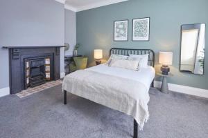 a blue bedroom with a bed and a fireplace at Host & Stay - Park House in Blythe