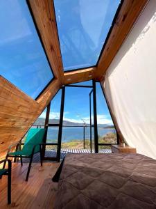 Zimmer mit einem Bett und einem großen Fenster in der Unterkunft Guatavita Glamping club in Bogotá