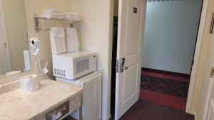 a bathroom with a microwave on top of a refrigerator at Oceanview Inn and Suites in Crescent City