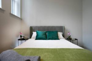1 dormitorio con 1 cama grande con almohadas verdes en Central Location, Stylish Apartment, Discounts, en Leeds
