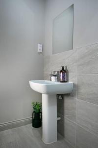 a bathroom with a white sink and a mirror at Central Location, Stylish Apartment, Discounts in Leeds
