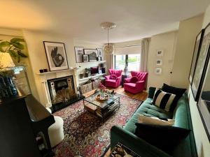 a living room with a blue couch and pink chairs at Townhouse near city centre in Dublin