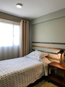 a bedroom with a bed and a table and a window at Container convertido en acogedor apartamento in Cajicá