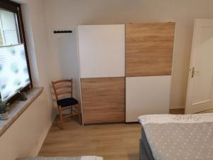a bedroom with a closet with a chair and a bed at Ferienhaus Lichtenberg 15 in Herleshausen
