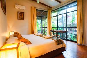 a bedroom with a bed and a large window at La Patarashca in Tarapoto