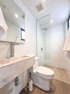 a white bathroom with a toilet and a sink at Charming 2BR With Pool in Casco Antiguo in Panama City