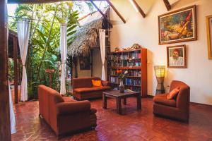 a living room with chairs and a book shelf at La Patarashca in Tarapoto