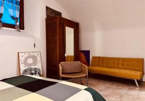 una camera da letto con un letto, un divano e una sedia di Questa casa non è un albergo a L'Aquila