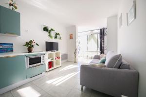 a living room with a couch and a tv at Les Appartements De Lina - Appartement Poseidon - Self Check-In - in La Grande-Motte