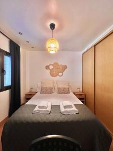 una camera da letto con un grande letto con due asciugamani di El Botones - Arenal a Madrid