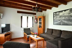 sala de estar con sofá y TV en Apartamentos Aires De Avin - Onis, en Avín