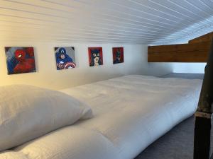 um quarto com uma cama com quatro pinturas na parede em Le Loft em Port-Sainte-Foy-et-Ponchapt