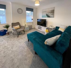 a living room with a blue couch and a chair at The Sashes - Apartment Two - FREE Parking - Ultrafast WIFI - Smart TV - Netflix - sleeps up to 6! Close to Poole Town Center & Sandbanks & Bournemouth in Poole