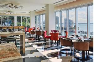 a restaurant with tables and chairs and a view of the water at 2B2B w Water View - FREE Parking - Pool - Lux Spa in Miami