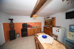 a kitchen with a table and a stove in it at Salaš Trikić in Aleksandrovo