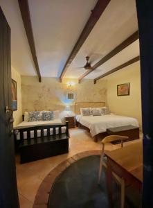 a bedroom with two beds and a table at Boutique Colonial House Hotel in Santo Domingo