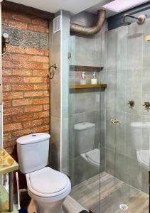 a bathroom with a toilet and a glass shower at Container convertido en acogedor apartamento in Cajicá