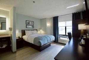 um quarto com uma cama e uma grande janela em Wingate by Wyndham Salisbury em Salisbury