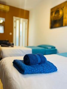 - une serviette bleue assise au-dessus d'un lit dans l'établissement Julian’s Place, à San Ġiljan