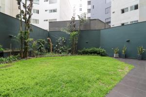 un jardín con una valla verde y césped en Astonishing 2BR With OCEAN View, en Lima