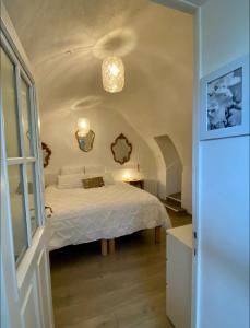 een slaapkamer met een wit bed in een kamer bij La glycine in Saint-Marc-Jaumegarde