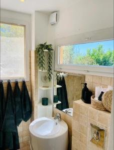 a bathroom with a sink and a window at La glycine in Saint-Marc-Jaumegarde