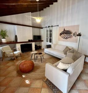uma sala de estar com sofás brancos e uma mesa em Finca El Sueño Andaluz em Villanueva de la Concepción