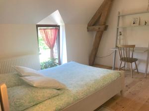 1 dormitorio con cama, ventana y escritorio en Le Vallon du Perche, en Champeaux-sur-Sarthe