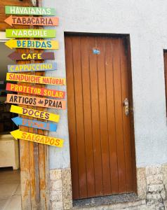 a bunch of signs on a wall with a door at Flat dos Anjos in Arraial do Cabo +6 photos