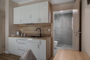 uma cozinha com armários brancos, um lavatório e um chuveiro em Soul House Gdansk Old Town em Gdansk