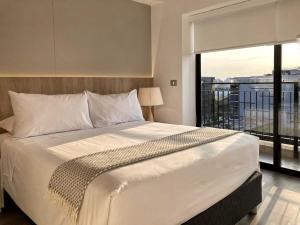 1 dormitorio con cama grande y ventana grande en Comfortable 1BR with modern balcony in San Isidro en Lima