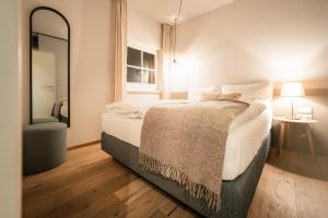 een slaapkamer met een groot bed en een spiegel bij Exklusive Seeappartements beim Elfenhaus in Grundlsee